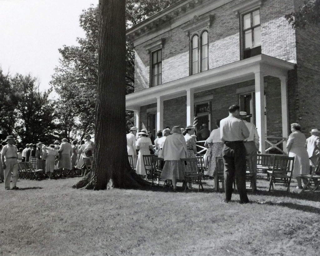 Group of people in front of brick home