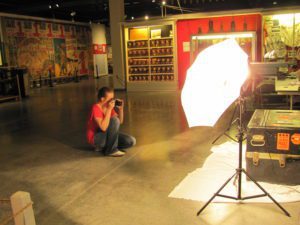 Intern photographing objects with a lighting stand