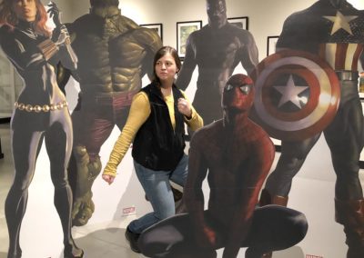 A young woman poses amid MARVEL superhero cutouts