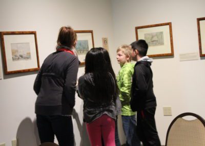 Family viewing watercolor paintings installed at the Sheboygan County Museum