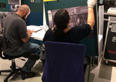 Two museum professionals examine and report on condition during the installation of a travelling exhibition from the Smithsonian Institution.